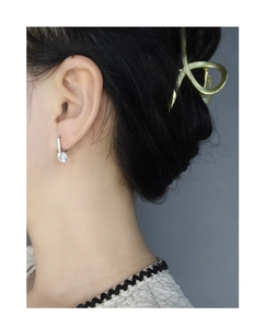 Close-up of a model wearing the silver U-shaped earring with a round sparkling zircon