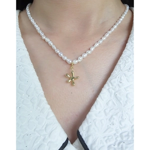 Collana di perle in argento S925 con ciondolo a stella dorata su una modella