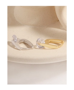Macro shot of minimalist gold and silver hoop earrings with sparkling round zircon stones