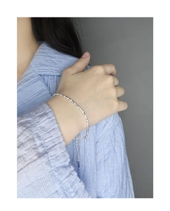 Macro detail of a shimmering S925 sterling silver chain bracelet with adjustable tail link