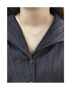 Detail of colorful beads on a silver bamboo chain necklace worn over a black shirt