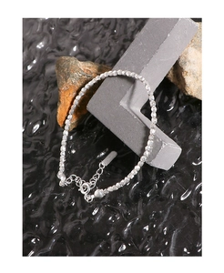 Detailed view of faceted S925 silver beaded bracelet with spring clasp on grey stone