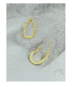 Macro shot of minimalist gold S925 sterling silver oval hoop earrings with polished finish