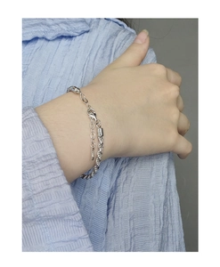 Close-up of a silver twisted rope chain bracelet with lobster clasp on a wrist
