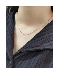 Detail of silver S925 bamboo chain necklace with colorful beads on a model's neck