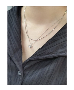 Detail of S925 sterling silver layered necklace with rainbow beads and heart pendant