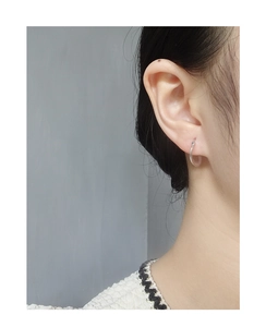 Close-up of minimalist S925 sterling silver hoop earrings worn on a model's ear