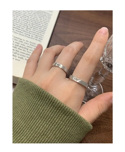 Détail de bagues de couple en argent S925 avec finition brossée et symbole de cœur