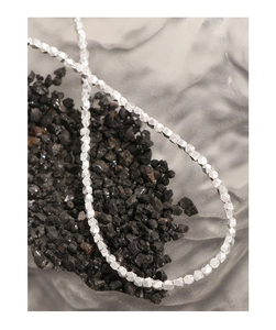 Close-up of S925 sterling silver necklace with geometric faceted beads on dark stone
