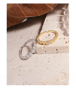 Detail of adjustable beaded rings in gold and silver with cubic zirconia on stone base