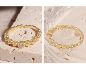 Detailed view of S925 sterling silver stamp on minimalist gold bead ring with cubic zirconia