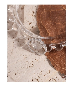 Detail of beaded S925 sterling silver ring with sparkling zircon stone on a textured rock