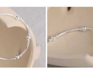 Macro shot showing S925 sterling silver stamp on minimalist beaded segmented bracelet