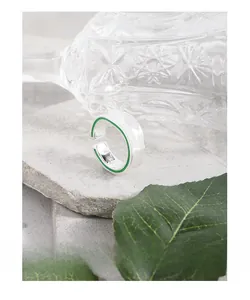 Détail d'une bague ajustable en argent S925 avec émail vert sur une surface en pierre