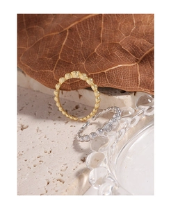 Detailed shot of gold and silver bead rings with cubic zirconia on a natural stone base