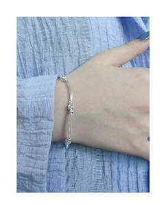 Detailed shot of minimalist S925 silver beaded bracelet worn on a woman's wrist