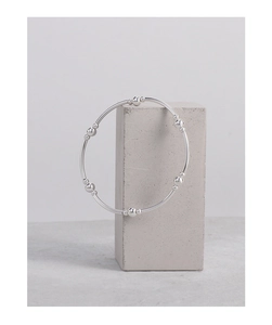 Minimalist S925 silver beaded bracelet displayed on a modern grey concrete pedestal