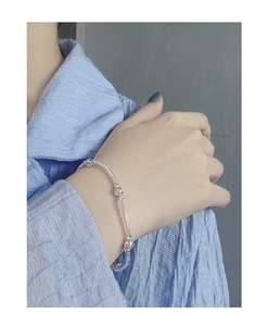Detailed view of a S925 sterling silver minimalist bead bracelet on woman's wrist