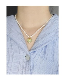 Détail du collier pendentif coeur en argent S925 avec perles blanches sur mannequin