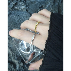 Minimalist S925 silver beaded rings with zircon stone shown on hand with glass