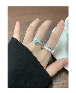 Détail d'une bague coeur en argent S925 avec zircon bleu et anneau large au doigt