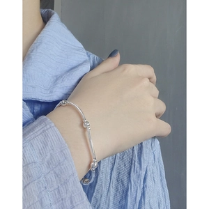 Minimalist S925 sterling silver beaded bracelet shown on model with polished finish
