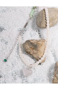 Detail view of pearl and green jade necklace with a silver heart pendant and extension chain