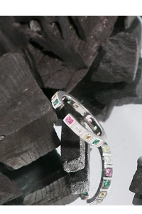 Detail shot of multi-color square zircons on an S925 silver open ring against charcoal