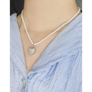 Collier cœur perle en argent S925 sur chemise bleue pour une esthétique minimaliste