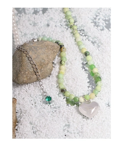 Macro detail of natural stone bead necklace with silver heart pendant and pearls