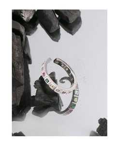 Macro shot of S925 sterling silver ring with colorful square-cut gemstones on mirror