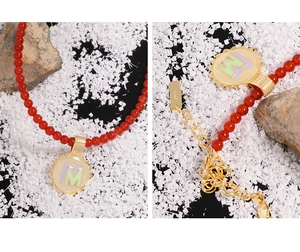 Detail of S925 sterling silver tag and gold sun pendant with red agate beads necklace