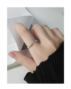 Détail d'une bague en argent S925 ornée de zircons bleus et jaunes portés