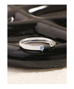 Gros plan d'une bague ouverte en argent S925 avec zircons bleu ciel et jaune clair