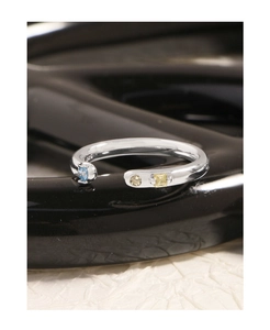 Détail macro d'une bague en argent S925 avec incrustations de pierres bleues et jaunes