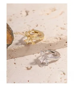 Detailed macro view of S925 sterling silver bow earrings in gold and silver finishes