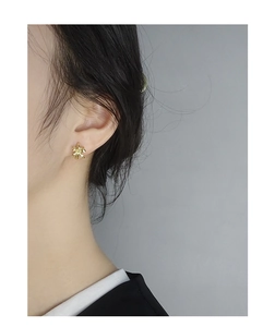 Close-up of minimalist gold bow earrings worn on model for a delicate jewelry look