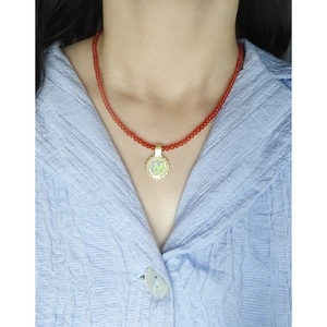 Minimalist red agate beaded necklace with a golden M letter pendant worn by a model