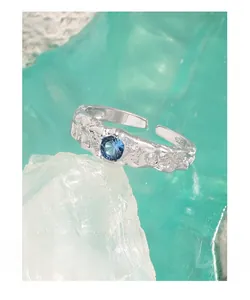 Macro shot of S925 silver ring featuring blue zircon and molten texture detail