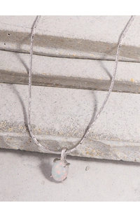 Vue détaillée du pendentif ovale en opale blanche sur une élégante chaîne en argent S925