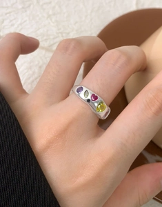 Detail of wide S925 silver ring featuring colorful zircon stones in various shapes