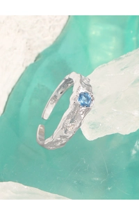 Detailed macro view of S925 sterling silver ring with blue zircon and lava texture