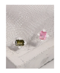 Makroaufnahme asymmetrischer Zirkonia-Ohrringe mit pinken und grünen Steinen