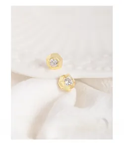 Macro shot of minimalist gold S925 silver earrings with irregular geometric zircon studs