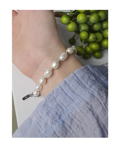 Close-up of baroque pearl bracelet with S925 sterling silver tag on female wrist
