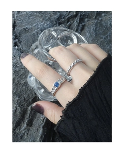 Detail view of silver textured lava rings set with ocean blue zircon on model finger