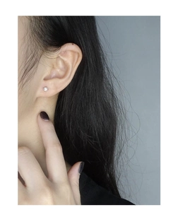 Puce d'oreille minimaliste en argent S925 avec opale portée sur le lobe d'oreille