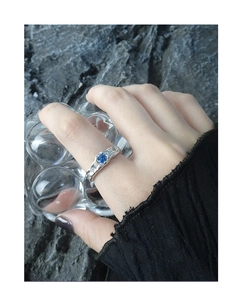 Detail of S925 silver ring with irregular texture and round blue zircon stone inlay