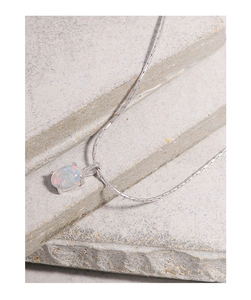 Détail macro du collier en argent S925 avec opale sur des marches en pierre grise