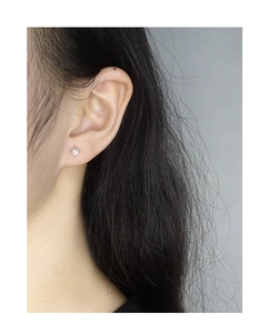 Gros plan d'une boucle d'oreille minimaliste en argent S925 avec opale ronde